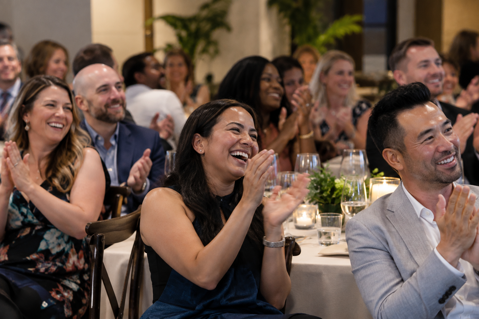 Illustrative company-event audience laughing and applauding